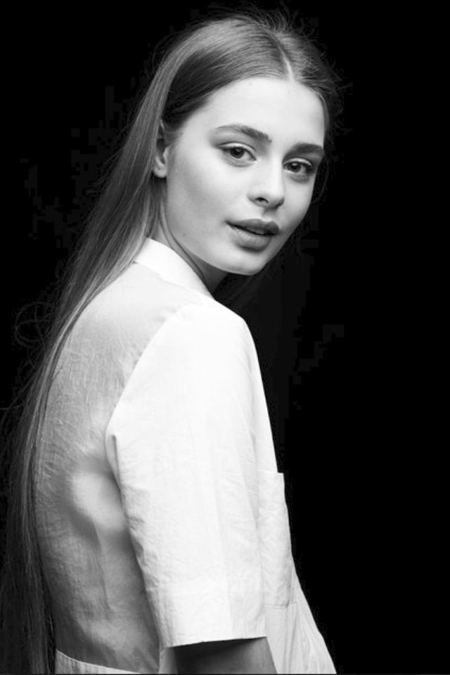 Sasha studio portrait. Dark background, glowing apperance.